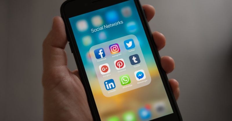 A person leveraging social media icons on their phone to generate more leads on LinkedIn.